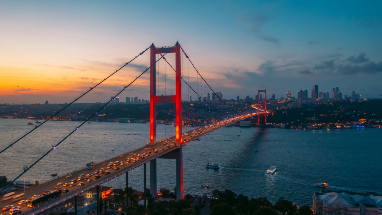 İstanbul Boğazı'nda gün batımında ışıklandırılmış Boğaziçi Köprüsü